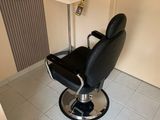 un fauteuil de coiffeur noir dans un coin de la pièce