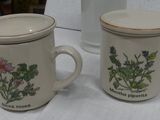 two coffee mugs sitting on a table next to each other