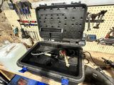 une boîte à outils contenant des outils, posée sur un établi