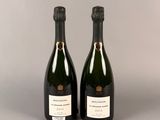 deux bouteilles de champagne posées l'une à côté de l'autre sur une table