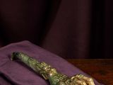 a close up of a knife on a purple cloth on a wooden table