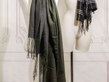 two mannequins with scarves on them in front of a wall