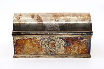 une vieille boîte en métal posée sur une surface blanche