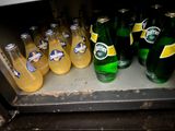 many bottles of beer on a shelf in a refrigerator