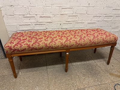 un banc recouvert d'un tissu à motifs floraux rouges et jaunes