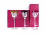 three wine glasses are sitting next to each other in front of a pink box