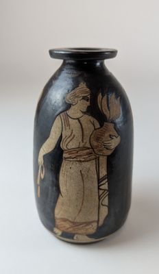 a black vase with a picture of a man holding a flower