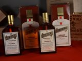 several bottles of liquor sitting on a table next to a box