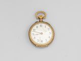 an antique pocket watch on a white surface with a white background