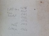 an old book with writing on it sitting on a table
