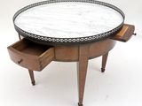 a round marble top coffee table with two drawers