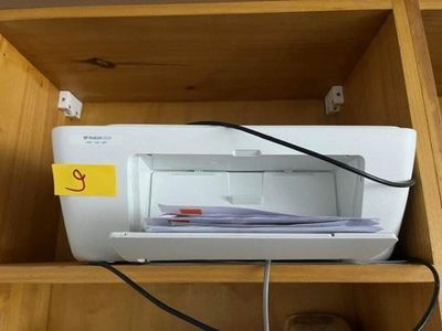 a printer sitting on top of a wooden shelf