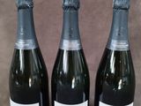 trois bouteilles de champagne posées les unes à côté des autres sur une table
