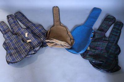 three pairs of gloves and a guitar case sitting on a table