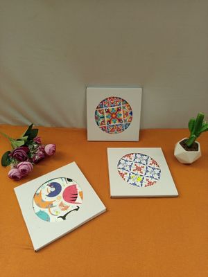 three coasters sitting on a table next to a potted plant