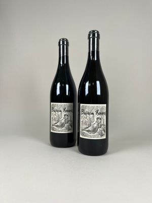 two bottles of wine sitting next to each other on a table