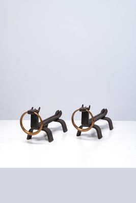 une paire de serre-livres en forme de chevaux, noirs et dorés, posés sur une table blanche