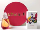un petit flacon de parfum à côté d'un coffret de parfum