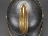an antique helmet with a gold decoration on the side