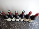 six bottles of wine are lined up in a row on a table