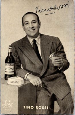 un homme en costume-cravate tenant une bouteille de vin
