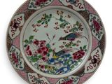 a plate with a bird and flowers on it
