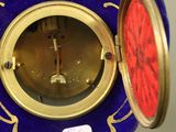 une horloge bleue et dorée avec un cadran rouge
