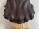 a chocolate covered ice cream cone on a white surface