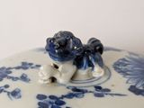 a blue and white bowl with a frog on top of it