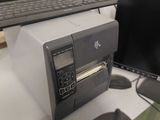 a computer and a printer sitting on a desk next to each other