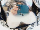 a person taking a picture of themselves in a silver vase