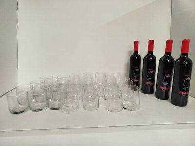 Des bouteilles de vin et des verres sont alignés sur une étagère
