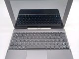a silver laptop with a black keyboard on a white surface