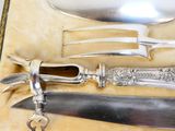 un couteau, une fourchette et un porte-couteau dans une boîte