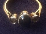 l'image d'une bague en or ornée d'une pierre noire