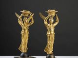 une paire de figurines en bronze doré représentant des femmes portant des paniers sur la tête