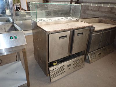 plusieurs plans de travail en inox et une vitrine dans une cuisine