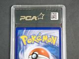 the pokemon card is in a plastic case on a table
