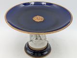 an image of a blue and gold plate with a statue on it