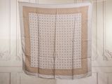 a white and tan blanket hanging on a clothes line