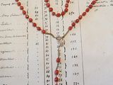 un chapelet et une croix posés sur un vieux livre