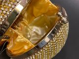 a gold purse with a diamond clasp on it