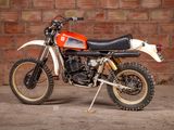a red and white dirt bike parked in front of a brick wall