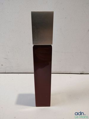 une image représentant une bouteille contenant un liquide posée sur une surface blanche