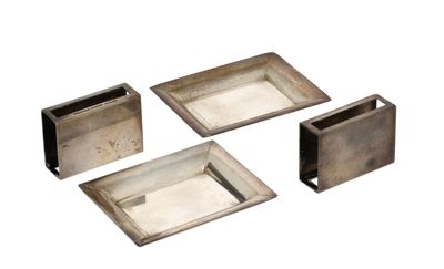 four pieces of silver metal are arranged on a white surface