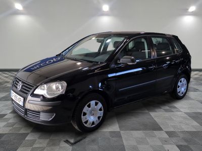 La voiture noire est garée sur le sol à damier du garage.