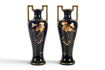 une paire de vases noirs et dorés ornés de feuilles sur fond blanc