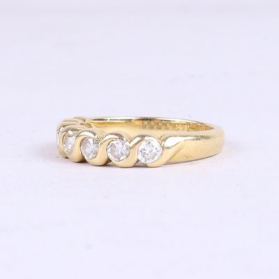 un gros plan d'une bague en or jaune sertie de trois diamants