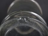 a close up of a glass bottle with a spider crawling on it