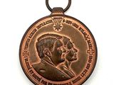 une vieille médaille en bronze sur laquelle figurent un homme et une femme
